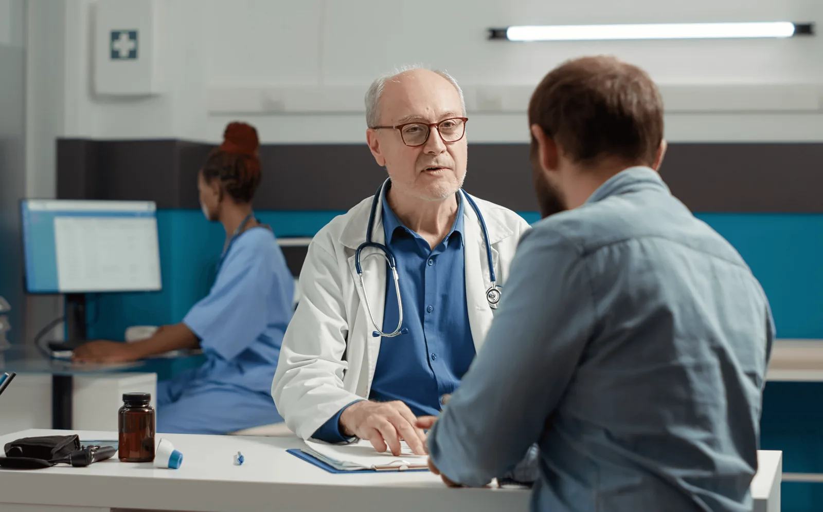 Médico conversando con un paciente en un consultorio.